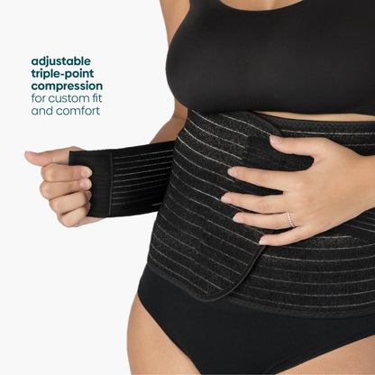 A woman adjusts the Shrinkx postpartum belly wrap for a custom fit
