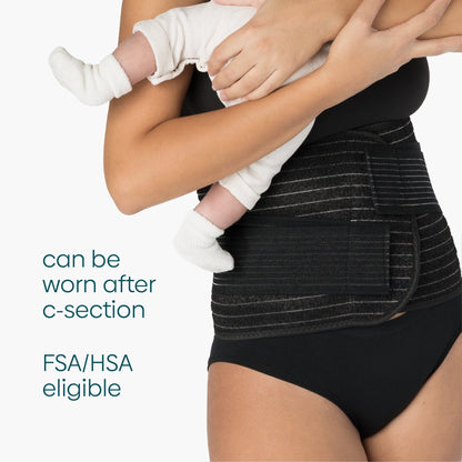 A woman wears the Shrinkx wrap which is FSA/HSA eligible as she holds her child
