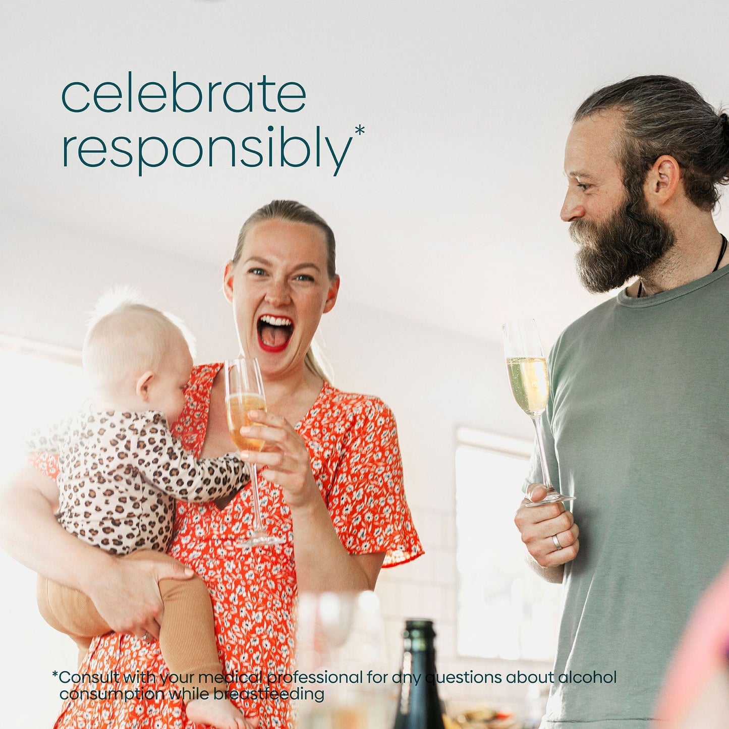 A woman holding her baby is excited to have champagne with her husband and she will use Milkscreen to test her breastmilk supply